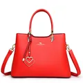 Elegante rode leren handtas voor dames met gouden kangoeroe-logo en hartvormige hanger - Rood