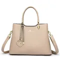 Elegante beige kunstleren handtas met gouden kangoeroelogo en hartvormige hanger - Khaki