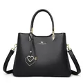 Classic black leather handbag with lychee pattern and gold heart-shaped charm pendant - Black