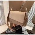 Detail of minimalist beige handbag showing woven texture flap and golden hardware accents - Khaki