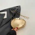 Mirror gold geometric clutch bag with sleek metal chain strap on gray blazer - Gold