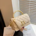 Gesteppte beige Ledertasche mit goldenem Metallgriff und D-förmigem Verschluss - Gebrochenes Weiß