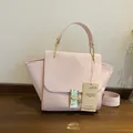 Pink vintage wing handbag with faux suede and crocodile texture on a wood surface - Pink
