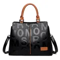 Black leather handbag for women featuring embossed lettering and brown handle accents - Yellow