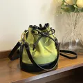 Quilted bucket bag in green suede with black trim and elegant drawstring bow design - Green