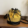 Mustard yellow suede bucket bag with black leather trim and elegant diamond quilting - Yellow