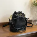 Sac seau matelassé en daim noir avec cordon de serrage et détails en métal doré - Noir