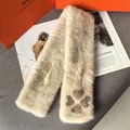 Detalle de bufanda de piel sintética beige con patrón de trébol y textura suave - Color Té con Leche