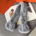 Close-up of the plush faux fur texture on a light gray scarf with premium packaging - Gray