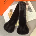 Close-up of thick black faux fur scarf with wide ends on an elegant grey fabric base - Black