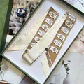 Detail von Seidenschals mit Handtaschen-Muster in einer geprägten grünen Geschenkbox - 5x120cm / Khaki