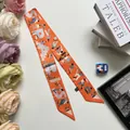 Detail van oranje bedrukte zijden sjaal met artistieke patronen en fijne randafwerking - Oranje