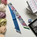 Detailansicht eines doppelseitigen Paisley- und Leopardenmusterschals an einem Taschengriff - 5x90cm / Blau