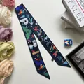 Close-up van de donkerblauwe polyester twilly sjaal met abstracte print en Paris tekst - Donkerblauw