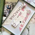 Eleganter weißer Twilly-Seidenschal mit rosa Buchstaben auf einer Vintage-Geschenkbox - Rosa Weiß