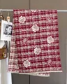 Detail of red and cream plaid scarf featuring realistic rose floral patterns and fringe - Red