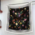 Dettaglio di sciarpa in seta floreale con bordo a pois neri e logo dorato in metallo - 90cm / Stile Floreale e Pois Nero