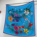 Dettaglio di un foulard di seta blu reale con illustrazioni floreali e bordi a contrasto - 90cm / Stile Floreale Blu Reale