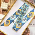 Gros plan d'un foulard en soie twilly aux motifs géométriques et dessins d'animaux - Bleu lac