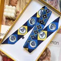 Détail macro d'un foulard étroit à motifs géométriques dans une boîte cadeau jaune - Bleu