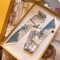 Macro detail van een zijden sjaal met bloemenprint in een gele geschenkverpakking - Beige