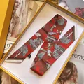 Detailopname van een luxe rode zijden sjaal met bloemenprint in gele geschenkdoos - Rood