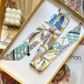Elegant bird print skinny silk scarf presented in a luxury yellow gift box for hair styling - Beige