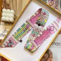 Slim silk-feel twilly scarf with vintage patterns displayed in a bright yellow gift box - Sakura Pink