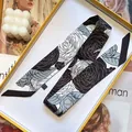 Klassischer Twilly-Seidenschal mit Kamelien-Blumenmuster in Schwarz und Weiß auf Tablett - Schwarz