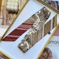 Κοντινό πλάνο μεταξωτού μαντηλιού με σχέδιο paisley και πουά σε κομψό κίτρινο κουτί δώρου - Κόκκινο Καφέ