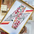 Pink floral silk twilly scarf with botanical prints in a yellow display box - White