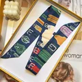 Detail of vintage print twilly scarf with belt motif inside a yellow gift box - Dark Blue Belt Buckle Style (S1860-10)