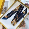 Blaues Seidentuch mit Goldketten-Print in eleganter gelber Geschenkbox auf Modemagazin - Langes Band / Marineblau