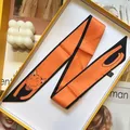 Detail of vibrant orange twilly silk scarf with cute orange cat illustration and black edges - Fox Orange (S291)