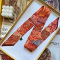 Detail of tropical zebra print silk twilly scarf in premium orange gift box packaging - 5x90cm / Red