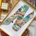 Detail of floral zebra print silk twilly scarf with wash label in luxury yellow box - 5x90cm / Green