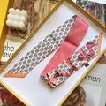 Detail eines Seidengefühl-Schals mit geometrischen Mustern in einer Geschenkbox - 5cmx90cm / Rosa