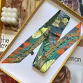 Detalle de una cinta de seda con estampado de hojas tropicales en una caja de regalo amarilla - Amarillo Naranja