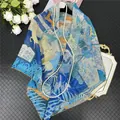Detail view of floral silk scarf with colorful animal prints and hemmed edges - Blue / Standard