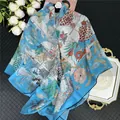 Detail van blauwe zijden sjaal met tropische giraf- en zebraprint op donkere achtergrond - Hemelsblauw