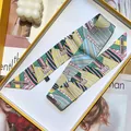 Elegant silk twilly scarf with geometric patterns and belt buckle design in a yellow gift box - Green