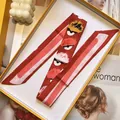 Detail van rood gestreepte zijden sjaal met monsteroogmotief in een gele geschenkdoos - Monster Oog Patroon Stijl (S1847-3)