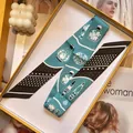Blau-schwarzer Twilly-Seidenschal in gelber Geschenkbox auf modischem Magazin-Hintergrund - Blau Schwarz Kontrast (S1841-1)