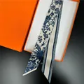 Detailed view of cream and navy toile de jouy pattern silk scarf in an orange gift box - 100cm x 6cm / Blue and White Botanical Floral Print (T451-1)