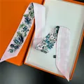 Twilly en soie rose à rayures et motifs floraux présenté sur un coffret cadeau - Rose