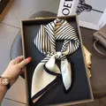 Elegant black and white striped silk scarf tied as a bow on a luxury display tray - Striped-White