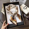 Élégant foulard en soie beige avec motifs géométriques et plumes dans son coffret - Trèfle Café