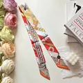 Detailed view of long silk twilly scarf with equestrian horse print and vibrant patterns - Red