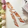 Elegant narrow silk scarf with equestrian horse print tied as a chic handbag accessory - Orange