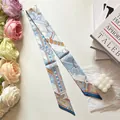 Elegant narrow silk twilly scarf featuring classic equestrian motifs with horses and belts - Blue
